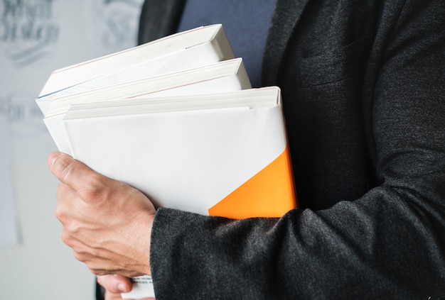 Free Photo closeup of hands holding stack of books
