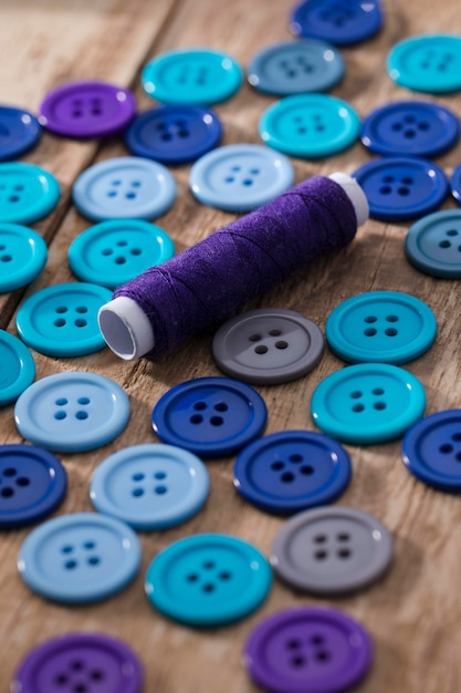 Free Photo high angle of blue buttons with reel of thread