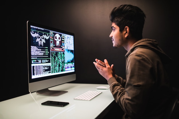 Free Photo indian hacker using computers for stealing data on desk dark
