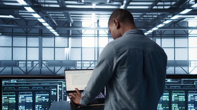 Free Photo man coding on data center testing failover scenarios using notebook