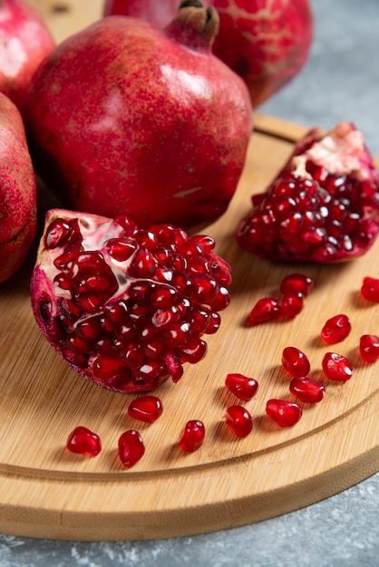 Free Photo sliced ripe pomegranate on a wooden board.