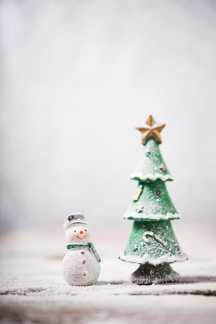Free Photo snowman next to a christmas tree