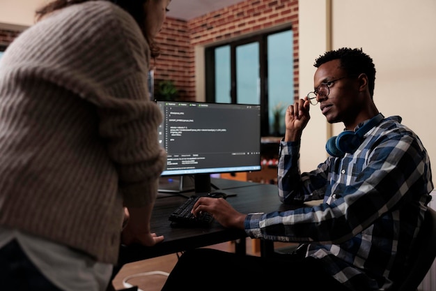 Free Photo software developers sitting at desk and developing a functional data encryption system. multiethnic cyber security team members in agency office writing cloud database processing algorithm.