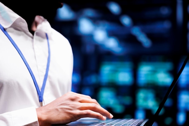 Free Photo specialist using laptop to do troubleshooting on data center mainframes with high computing power enabling hyperscale server hub to support demanding applications such as machine learning workloads