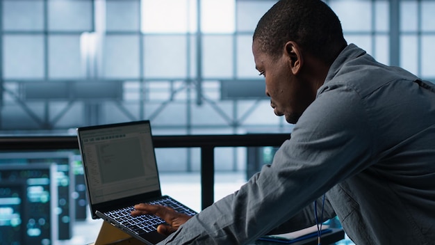 Free Photo technician in data center using programming languages on laptop