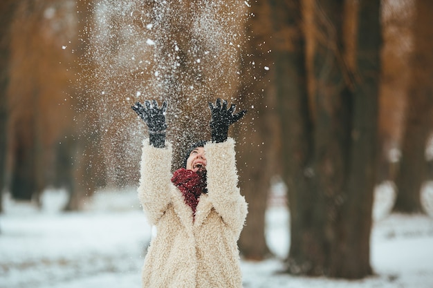 Free Photo young beautiful woman throws snow over head