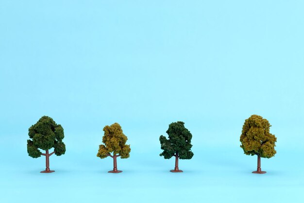 Photo artificial trees to scale on a blue background. isolated trees.