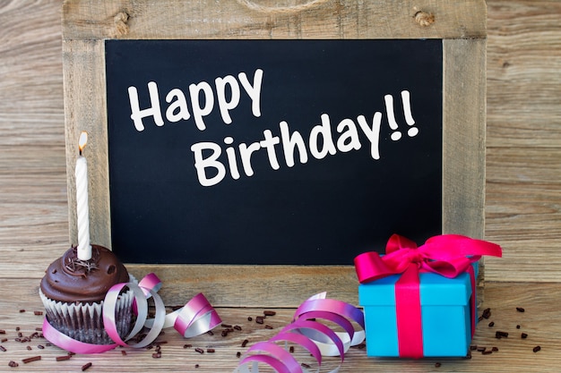 Photo birthday greetings on black chalkboard with  cupcake and gift box