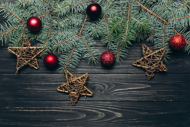 Photo christmas or new year dark wooden background, xmas black board framed with season decorations.