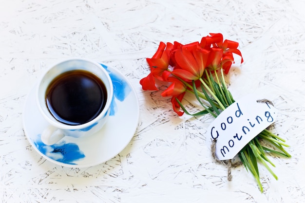 Photo coffee on white background and flowers. tulip. spring. morning. march 8. women's day