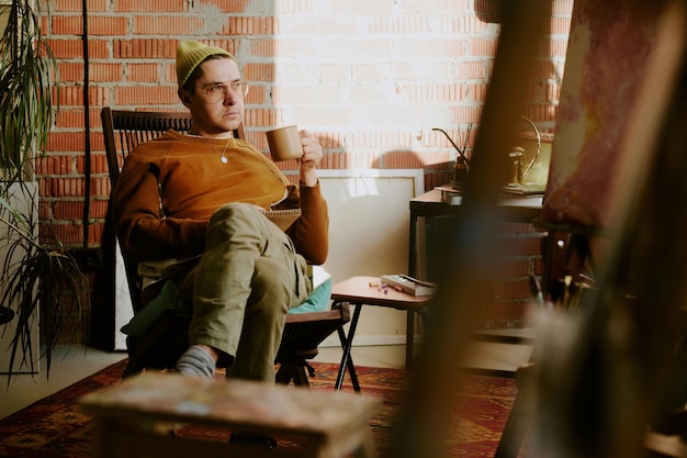 Photo creative man relaxing in art studio