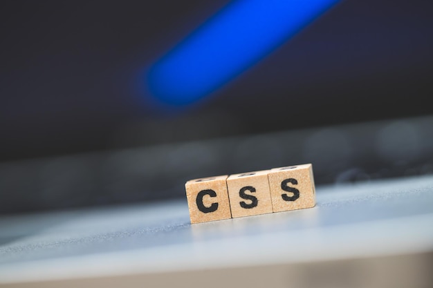 Photo css web language wooden cubes with letters css lying on a laptop concept for style sheet language