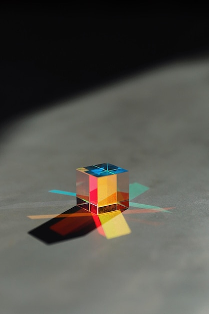 Photo cube shape on multi colored diagram on table
