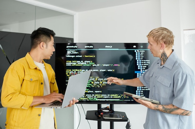 Photo developers arguing about programming code on computer screen