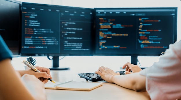 Photo female programer taking a note while young skilled web developer present program while computer displayed program code at modern office company java script web design concept burgeoning