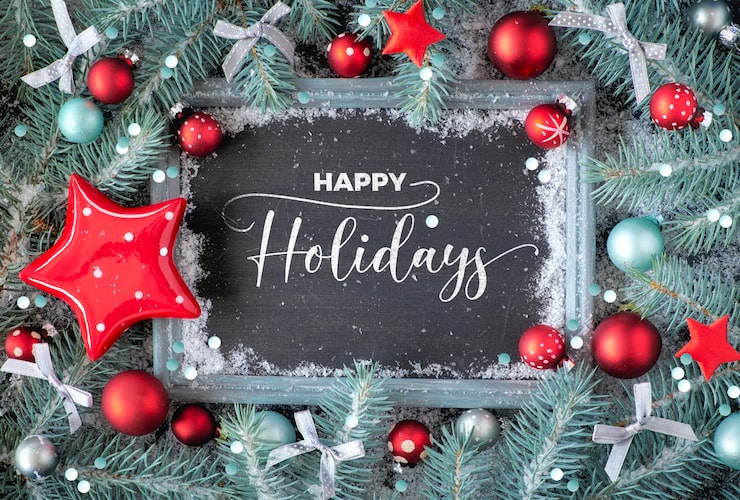 Photo green and red christmas with decorated chalk board. decorated fir twigs around chalk board on rustic wood with snow. flat lay with text