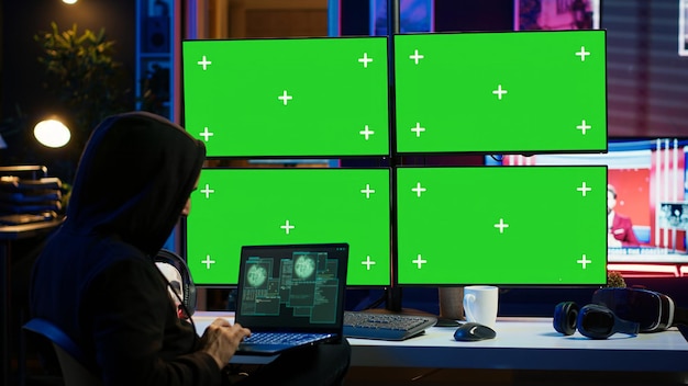 Photo hacker using chroma key computer and notebook to make malware scripts
