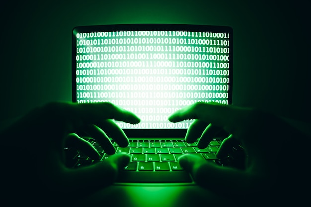 Photo hacker using laptop to coding virus or malware for hacking internet server cyber attack