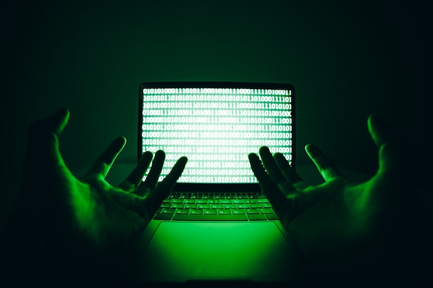 Photo hacker using the laptop computer to coding virus or malware for hacking internet server