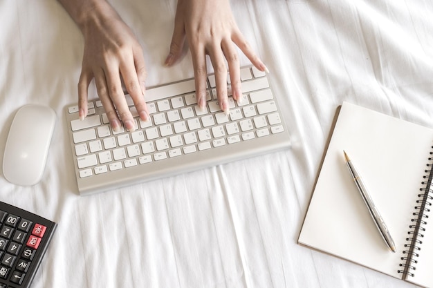 Photo high angle view of woman using computer on bed