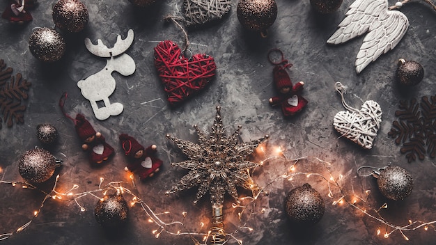 Photo holiday frame of christmas decorations on blue dark stucco concrete background with fir branch, gold balls, stars, christmas socks and toys. elegant new year`s. top view.