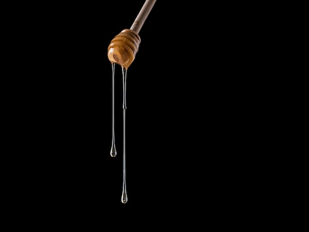 Photo honey flows from dipper