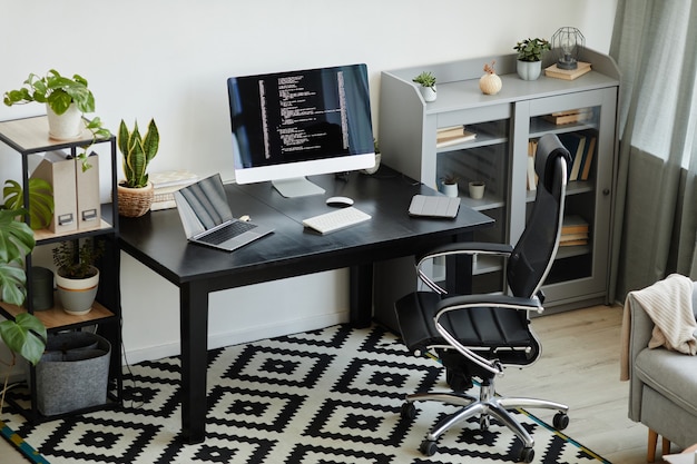 Photo image of modern office with table with computer monitor and laptop on it workplace for computer programmer