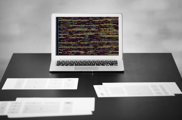 Photo laptop and documents on table in office