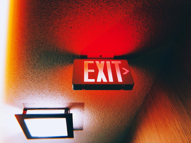 Photo low angle view of illuminated exit sign on ceiling