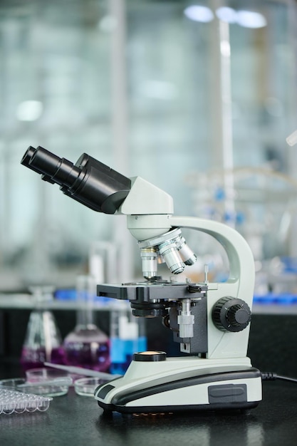 Photo microscope standing against glassware