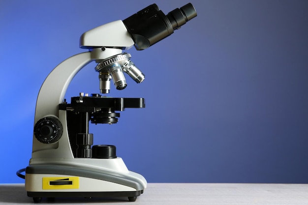 Photo microscope on table on color background