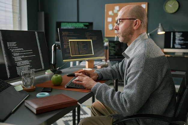 Photo middle aged caucasian man coding on computer in modern office workspace