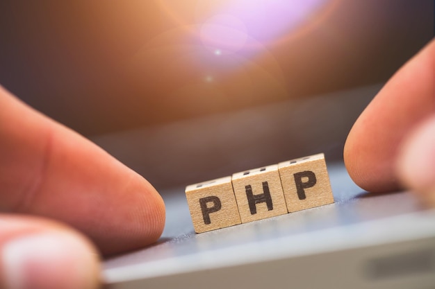 Photo php programming web language wooden cubes with letters php lying on a laptop concept