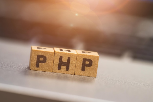 Photo php programming web language wooden cubes with letters php lying on a laptop concept