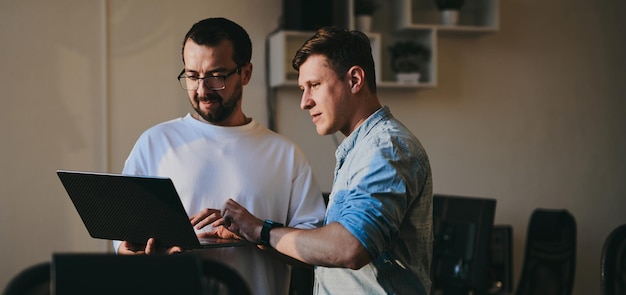 Photo portrait of two professional male programmers working on computer in diverse offices modern it technologies development of artificial intelligence programs applications and video games concept