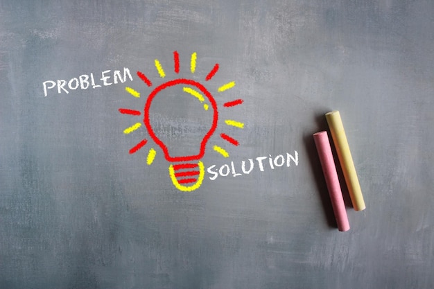Photo problem solving idea chalkboard drawing image of lightbulb with text problem and solution