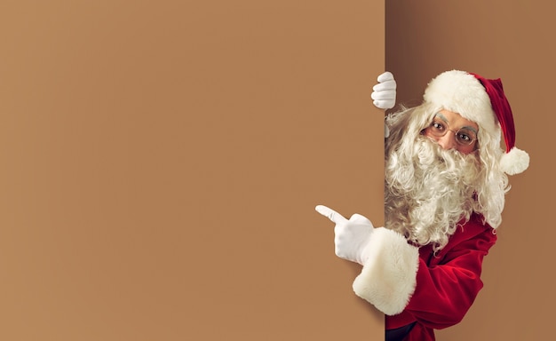 Photo santa claus indicates a blank space for your christmas text