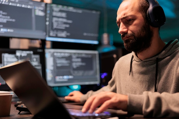 Photo software developer programming user interface on computer and compiling source code with html script and algorithms. coding cloud computing online program on multiple screens at night.