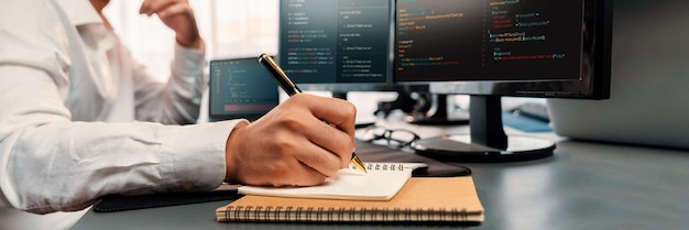 Photo software engineer working on application development on his computer display code and script on monitor at tech company office workplace application developer solving and writing code trailblazing