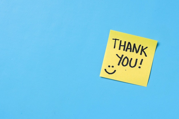 Photo sticky notes with text thank you on blue background with copy space