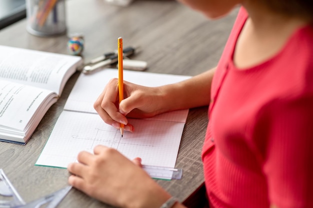 Photo student with ruler and pencil drawing in notebook