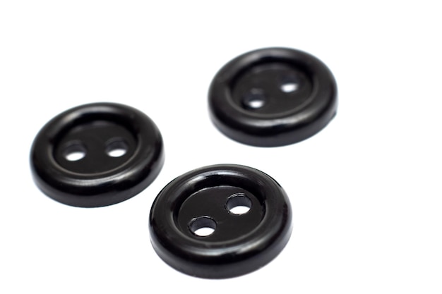 Photo three black plastic buttons isolate on a white background