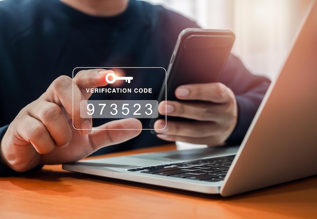 Photo two factor authentication or 2fa concept verification code with key icon press by man hand while using smart phone and laptop computer for validate password secure steps cyber security technology